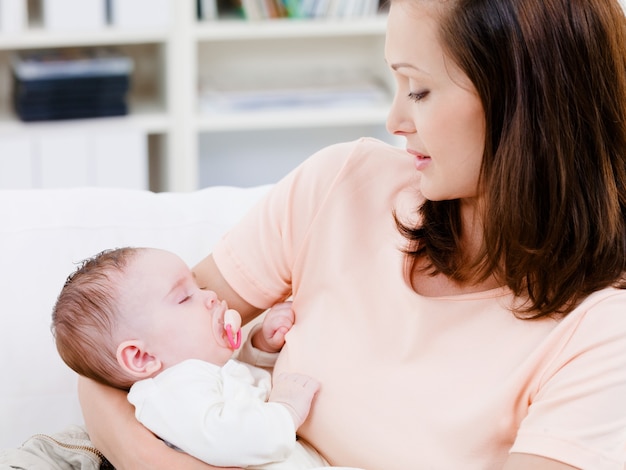 Slapende baby op de handen van de moeder