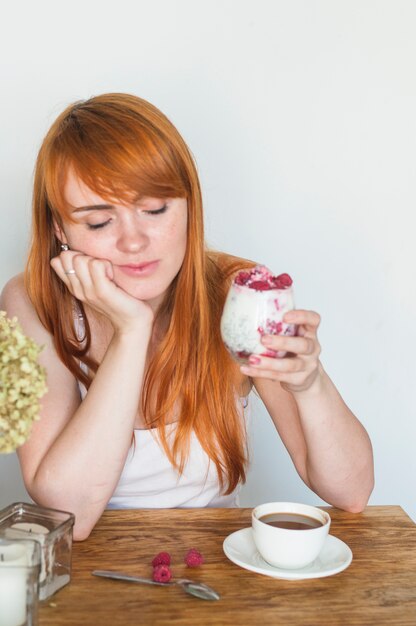 Slaperig jong glas van de vrouwenholding yoghurt met frambozen