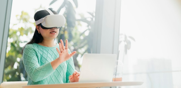 Slimme aantrekkelijke aziatische vrouwelijke bedrijfseigenaar draagt een virtual reality-bril geniet van een informele metaverse ontmoeting met concentraat in café-restaurant Aziatische vrouw met behulp van oculus rift-headset in café