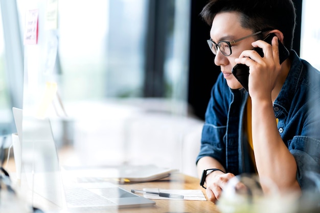 Slimme aantrekkelijke positieve Aziatische zakelijke man met een bril werk op afstand nieuwe normale levensstijl handgebruik laptop teleconferentie onlive videogesprek vergadering externe zakelijke ideeën concept