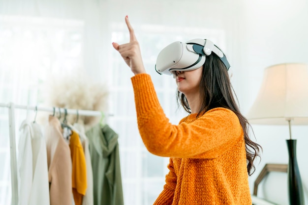 Slimme aziatische zakenvrouw woont online virtuele vergaderingspresentatie bij nieuwe collecties doekmode ingesteld op haar wereldwijde klant met behulp van virtual reality-technologie vr-headset thuisstudio overdag