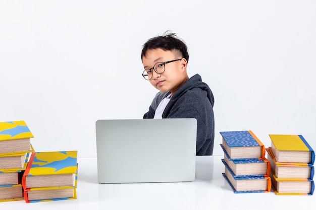 Slimme jongen met laptop en boeken