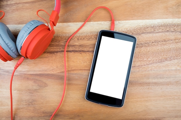 Slimme telefoonapparaten met leeg wit scherm op houten bureau.