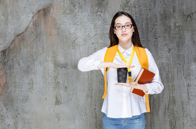 Slimme vrouwelijke student in glazen met boek en kopje koffie. hoge kwaliteit foto