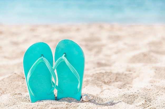 Slippers vast in het zand op een zandstrand aan zee of oceaan Premium Foto
