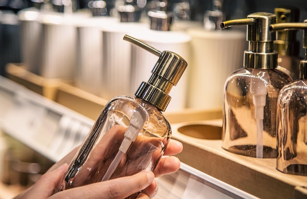 Sluit een dispenser voor vloeibare zeep in vrouwelijke handen in de winkel
