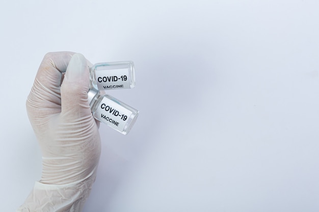 Sluit een flesje met covid-19-vaccin in de hand van een wetenschapper of arts