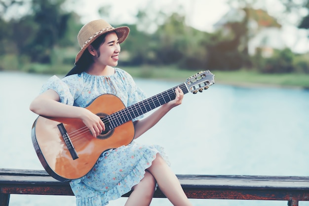 Sluit omhoog beelden van de handen die van de vrouw akoestische gitaar spelen