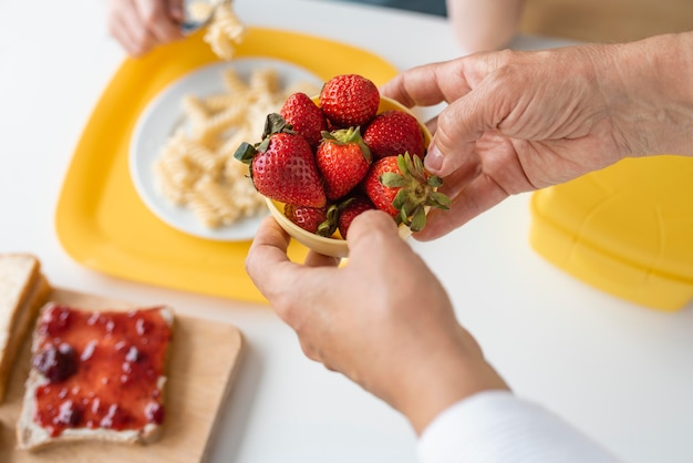 Sluit omhoog de aardbeienkom van de grootouderholding