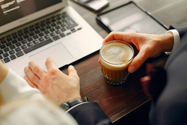 Sluit omhoog de mens die met laptop bij de lijst werkt