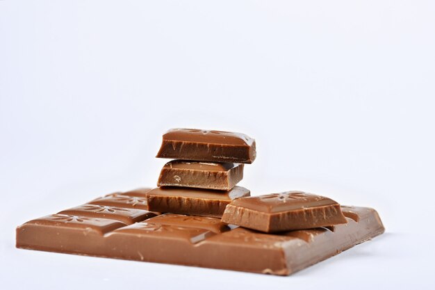 Sluit omhoog een chocoladereep op witte achtergrond wordt geïsoleerd die.