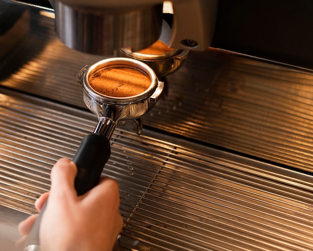 Sluit omhoog hand die koffie met machine voorbereidt