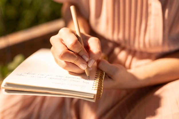 Sluit omhoog hand die op notitieboekje schrijft