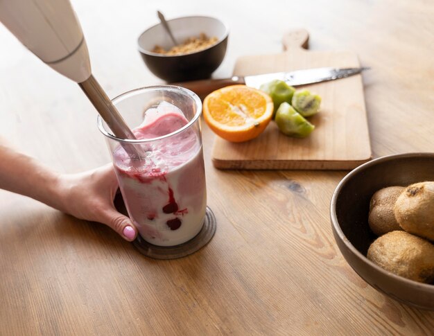 Sluit omhoog hand die smoothie voorbereidt