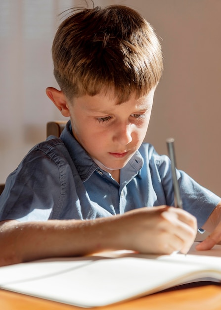 Sluit omhoog jong geitje dat op notitieboekje schrijft