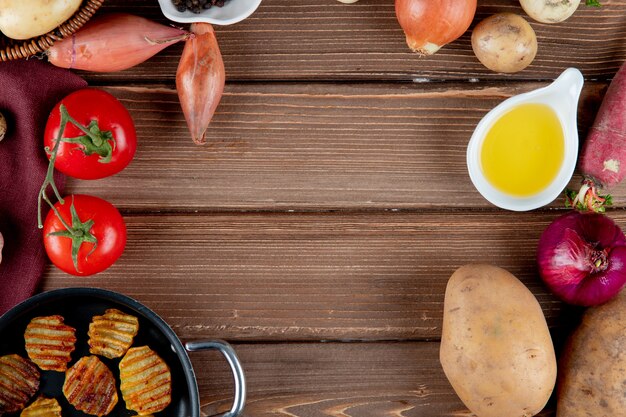 Sluit omhoog mening van groenten als aardappel van de tomatenui met boter en chips op houten achtergrond met exemplaarruimte