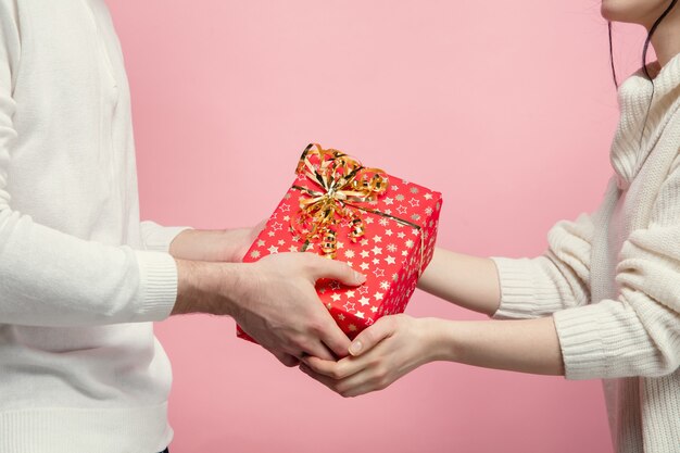 Sluit omhoog mooi paar verliefd op roze studiomuur