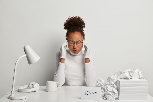 Sluit omhoog op jonge mooie vrouw aan haar bureau