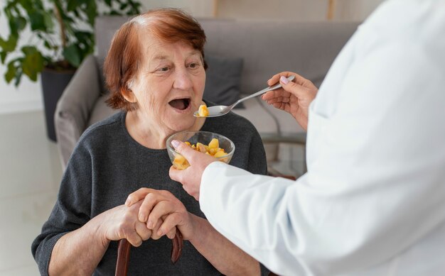 Sluit omhoog oude vrouw die wordt gevoed