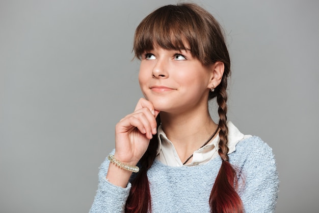 Sluit omhoog portret van een nadenkend glimlachend schoolmeisje