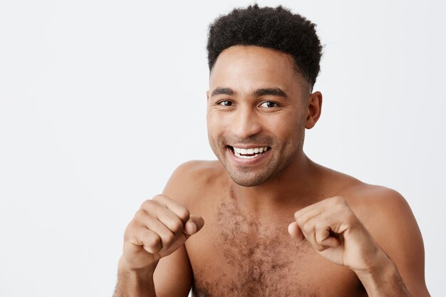 Sluit omhoog portret van professionele atletische Afrikaanse donkerhuidige bokser met donker krullend haar die zich in strijd bevinden stellen, stellend voor de fotosessie van het tijdschrift. Kopieer ruimte.