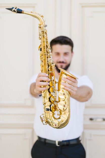 Sluit omhoog saxofoon die door musicus wordt gehouden