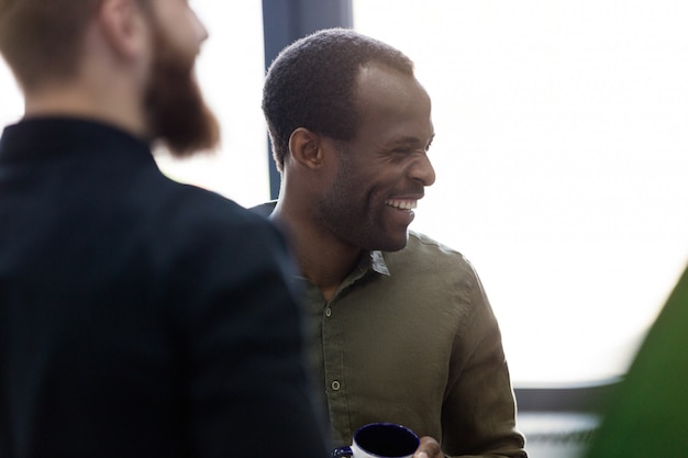 Sluit omhoog van een Afrikaanse mens die zich met zijn collega's bevindt