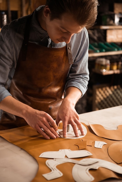 Sluit omhoog van een mannelijke schoenmaker die met leertextiel werkt