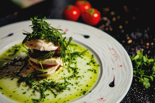 Sluit omhoog van gelaagde carpese salade met mozarella en tomaat en rucola