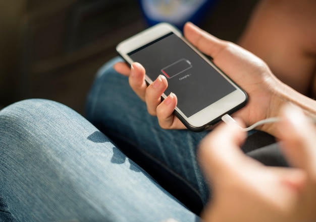 Sluit omhoog van handen die mobiele telefoon laden