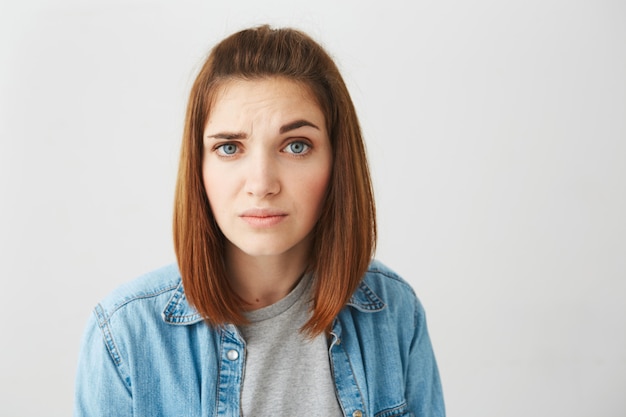 Sluit omhoog van ontstemd jong mooi meisje dat brow opheft.