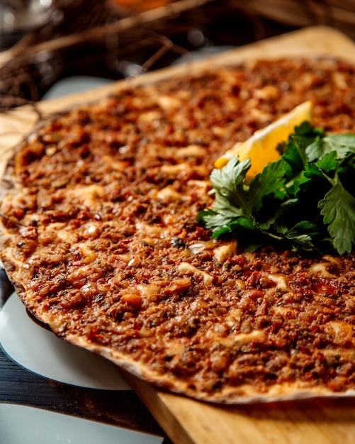 Sluit omhoog van Turkse pizza lahmajun met citroen en peterselie