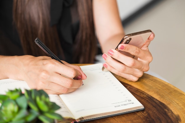 Gratis foto sluit omhoog vrouw schrijvend van telefoon