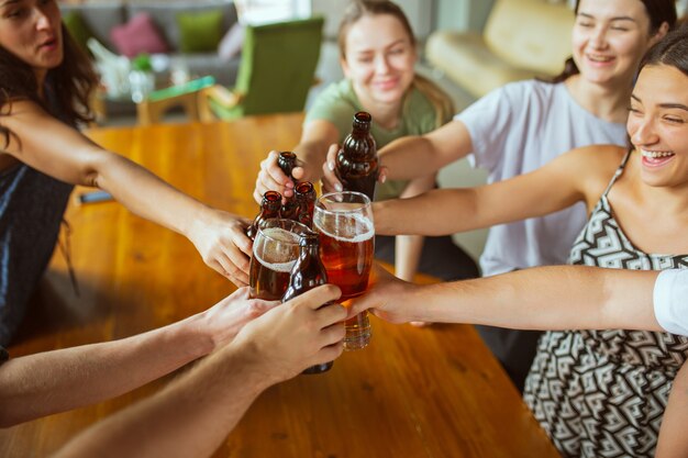 Sluit rammelende. Jonge groep vrienden die bier drinken, plezier hebben, lachen en samen vieren.