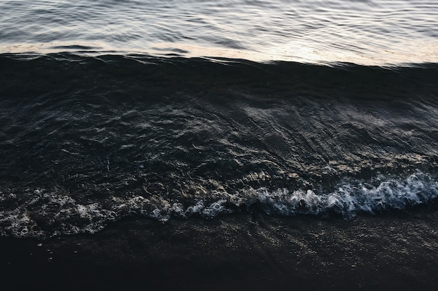 Gratis foto sluit schot van overzeese golven die de kust raken