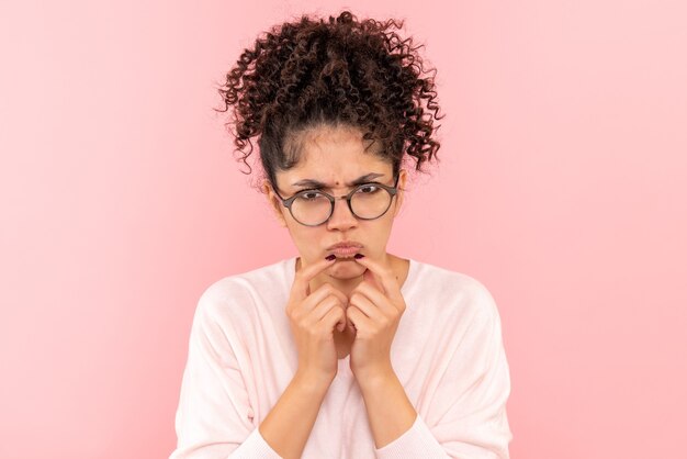 Sluit vooraanzicht van jonge vrouw verward op roze