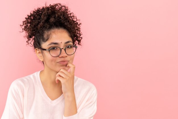 Sluit vooraanzicht van jonge vrouwelijke denken op roze