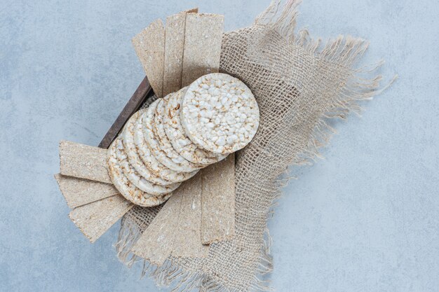 Smaakvolle knäckebröd op handdoek in de doos op marmer.