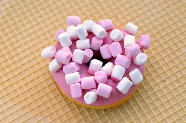 Smakelijke donut in roze glazuur met marshmallow close-up