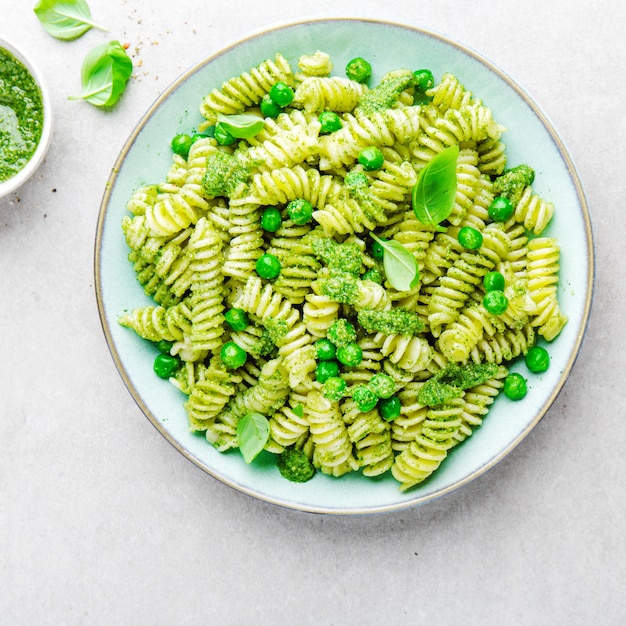 Gratis foto smakelijke eetlustopwekkende pasta met pesto op plaat