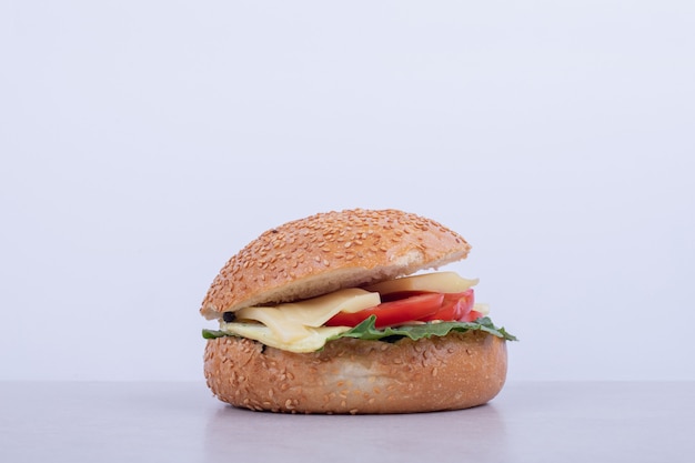 Smakelijke hamburger met tomaat, kaas, sla op een witte ondergrond.