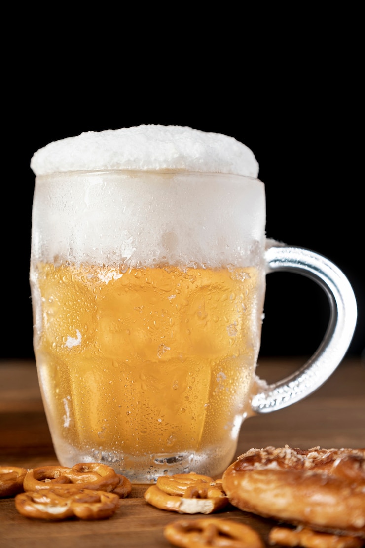 Gratis Foto smakelijke mok bier met schuim en pretzels