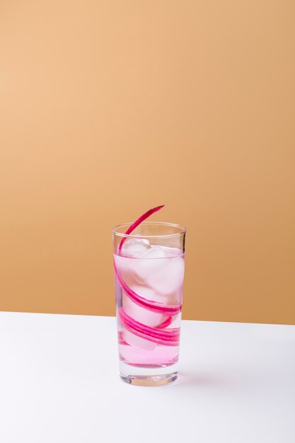 Smakelijke roze drank met ijsblokjes op witte lijst