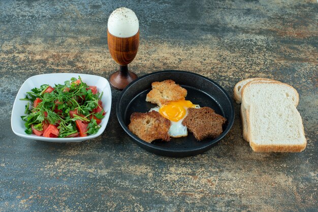 Smakelijke salade met gesneden brood en gekookte eieren op marmeren achtergrond