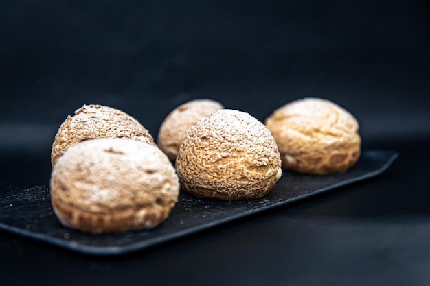 Gratis foto smakelijke shu-cakes op een zwarte achtergrond