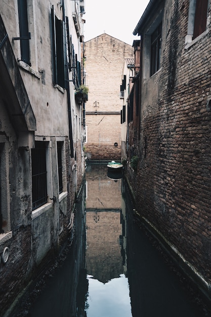 Smalle kleine rivier loopt een stad in de voorsteden tussen bakstenen gebouwen