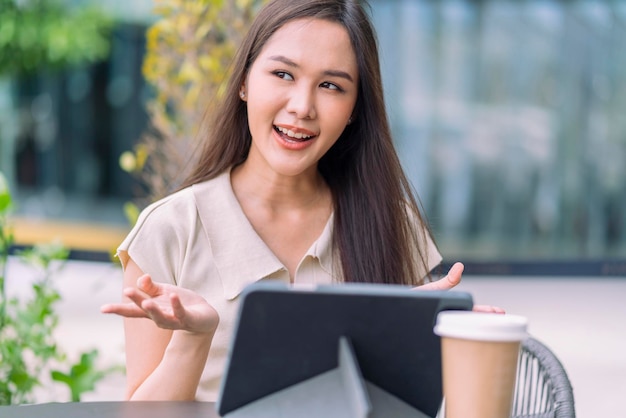 Smart casual aziatische digitale nomade opstarten bedrijf ondernemer klein bedrijf eigenaar werk en discussie videoconferentie met klant op tuin balkon exterieur achtergrond Aantrekkelijke vrolijke vrouw