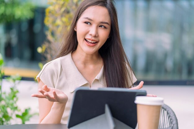 Smart casual aziatische digitale nomade opstarten bedrijf ondernemer klein bedrijf eigenaar werk en discussie videoconferentie met klant op tuin balkon exterieur achtergrond Aantrekkelijke vrolijke vrouw