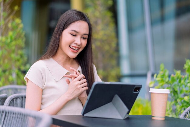 Smart casual aziatische digitale nomade opstarten bedrijf ondernemer klein bedrijf eigenaar werk en discussie videoconferentie met klant op tuin balkon exterieur achtergrond Aantrekkelijke vrolijke vrouw