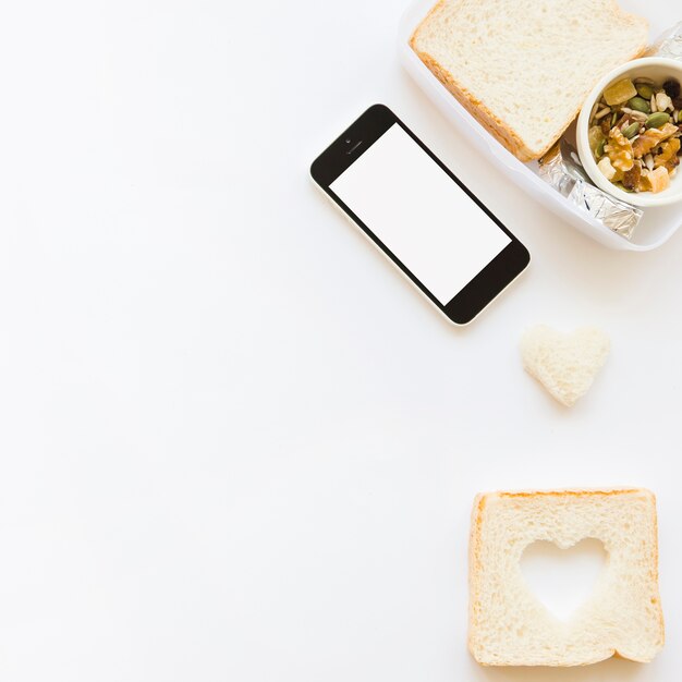 Smartphone in de buurt van toast en muesli